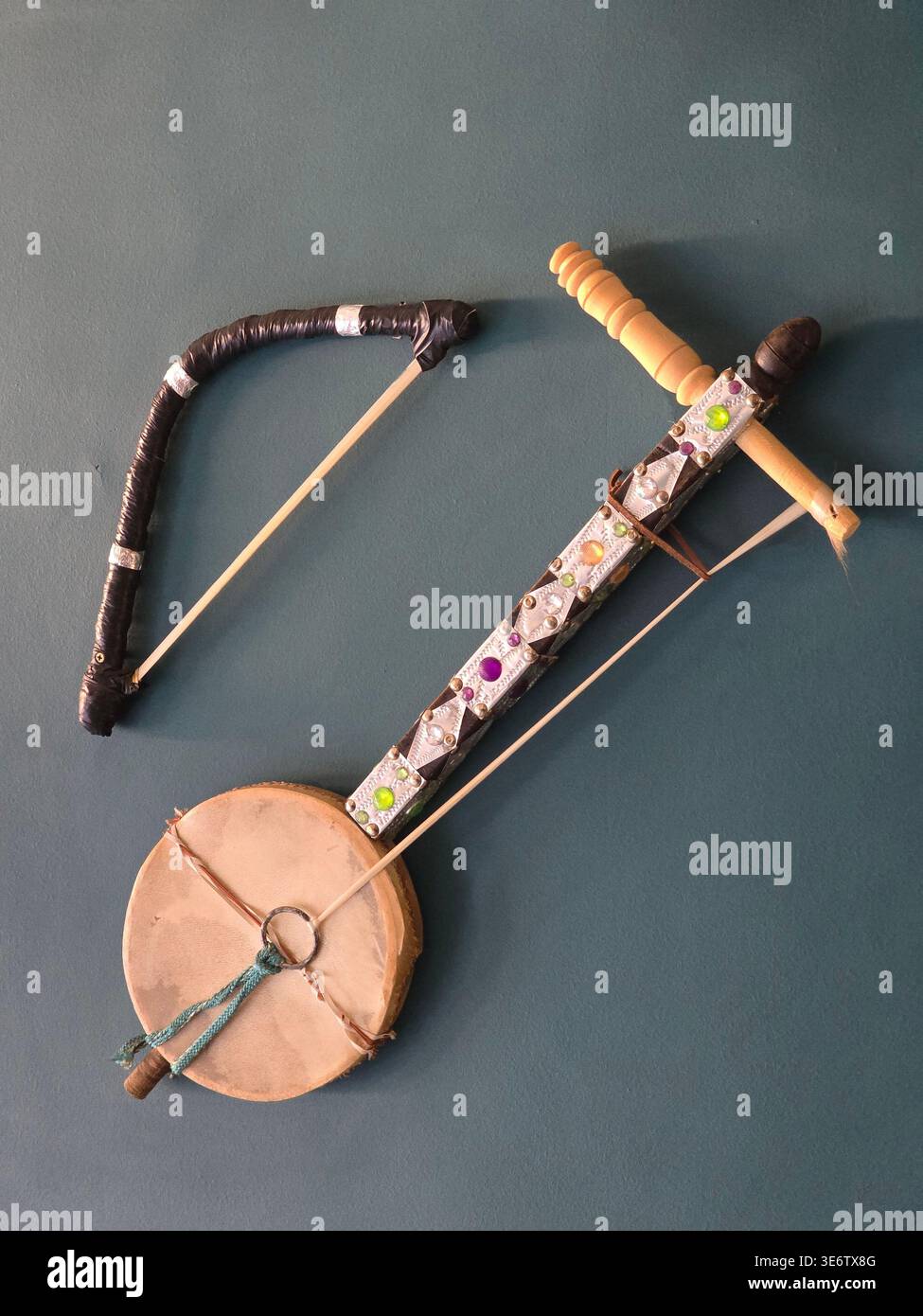 Authentisches marokkanisches Kulturerbe mit einem traditionellen Berber-Musikinstrument, lokaler Flora mit einem großen Kakteen und hausgemachtem traditionellem Brot. - Smartphone-aufgenommenes Stockfoto