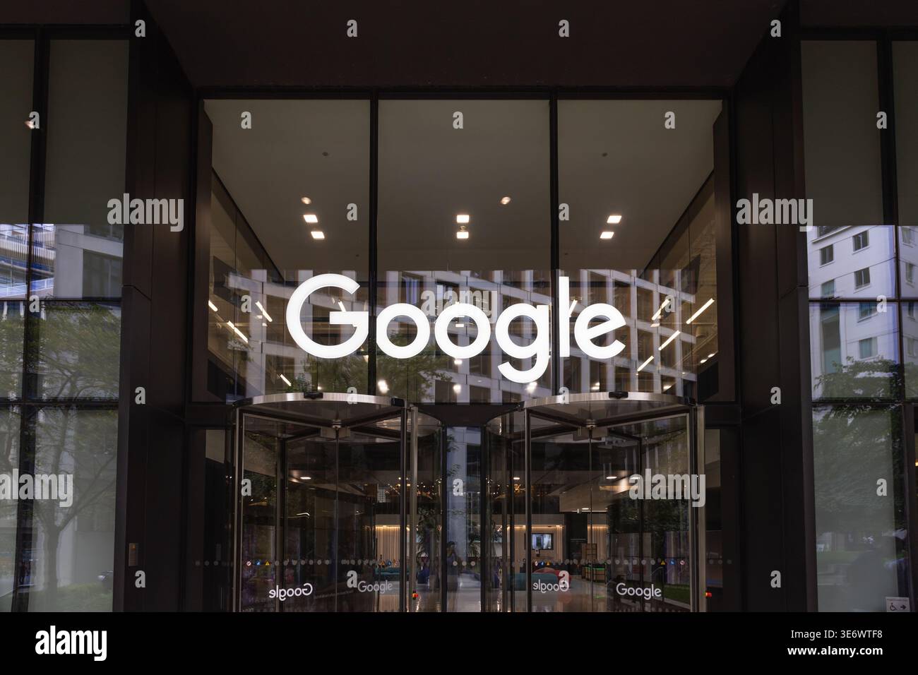 Eingang des Geschäftsgebäudes von Google mit beleuchtetem Logo. London, Vereinigtes Königreich, 1. Oktober 2023 Stockfoto