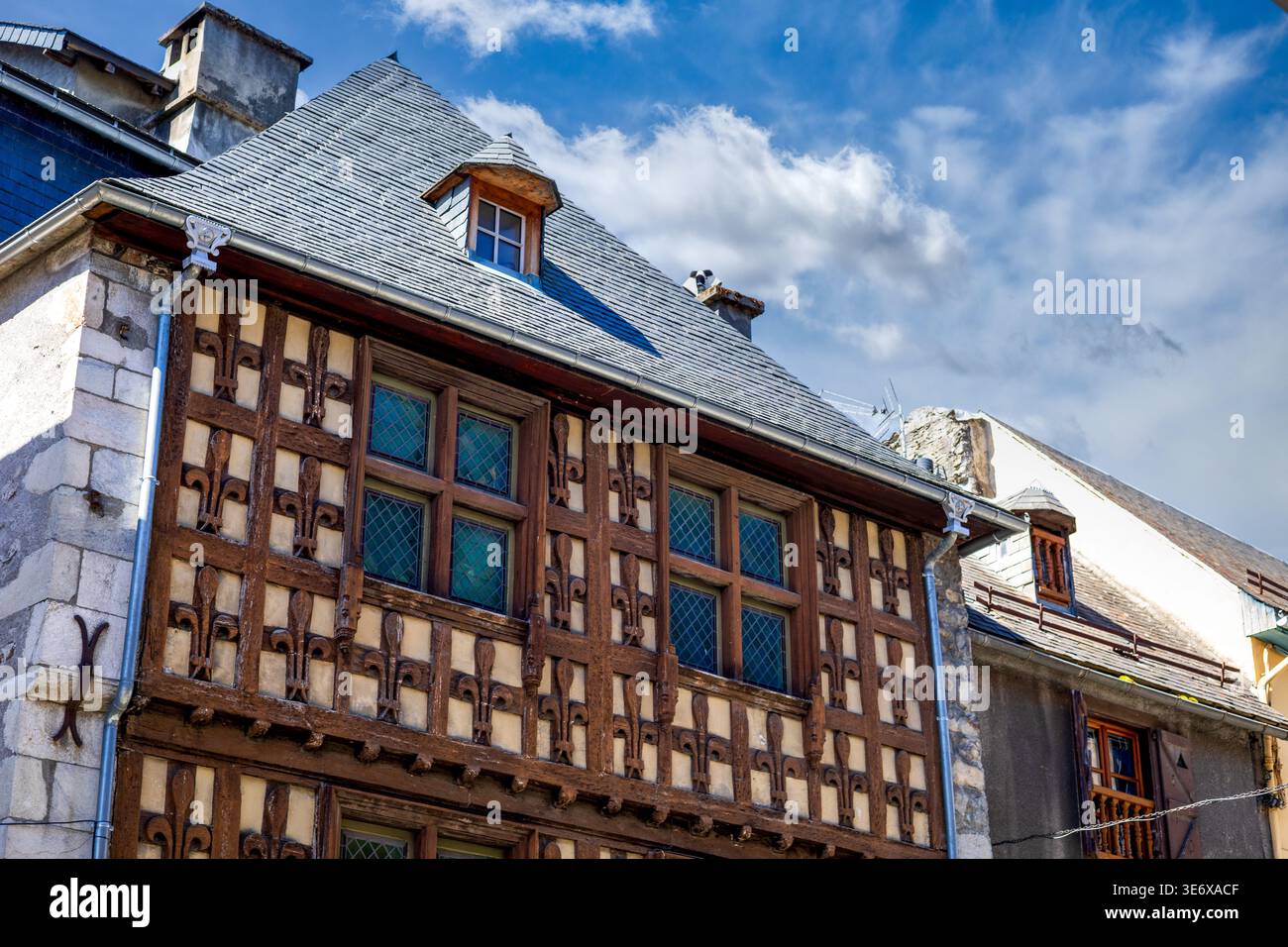 Fassade eines historischen Gebäudes mit Fleur-de-Lis in Arreau, Midi-Pyrénées, Frankreich Stockfoto