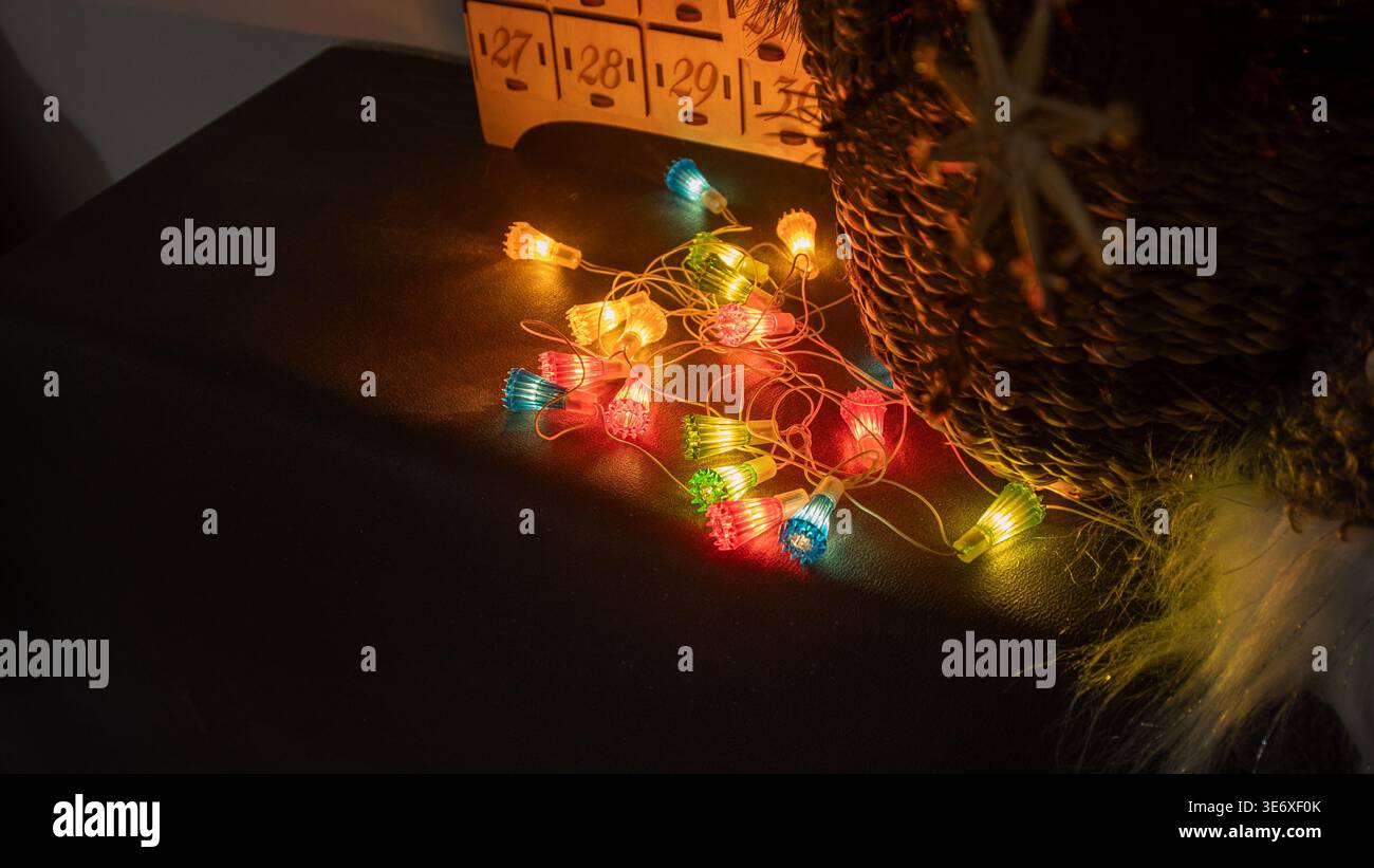 Bunte Lichterketten auf dunkler Oberfläche. Stockfoto