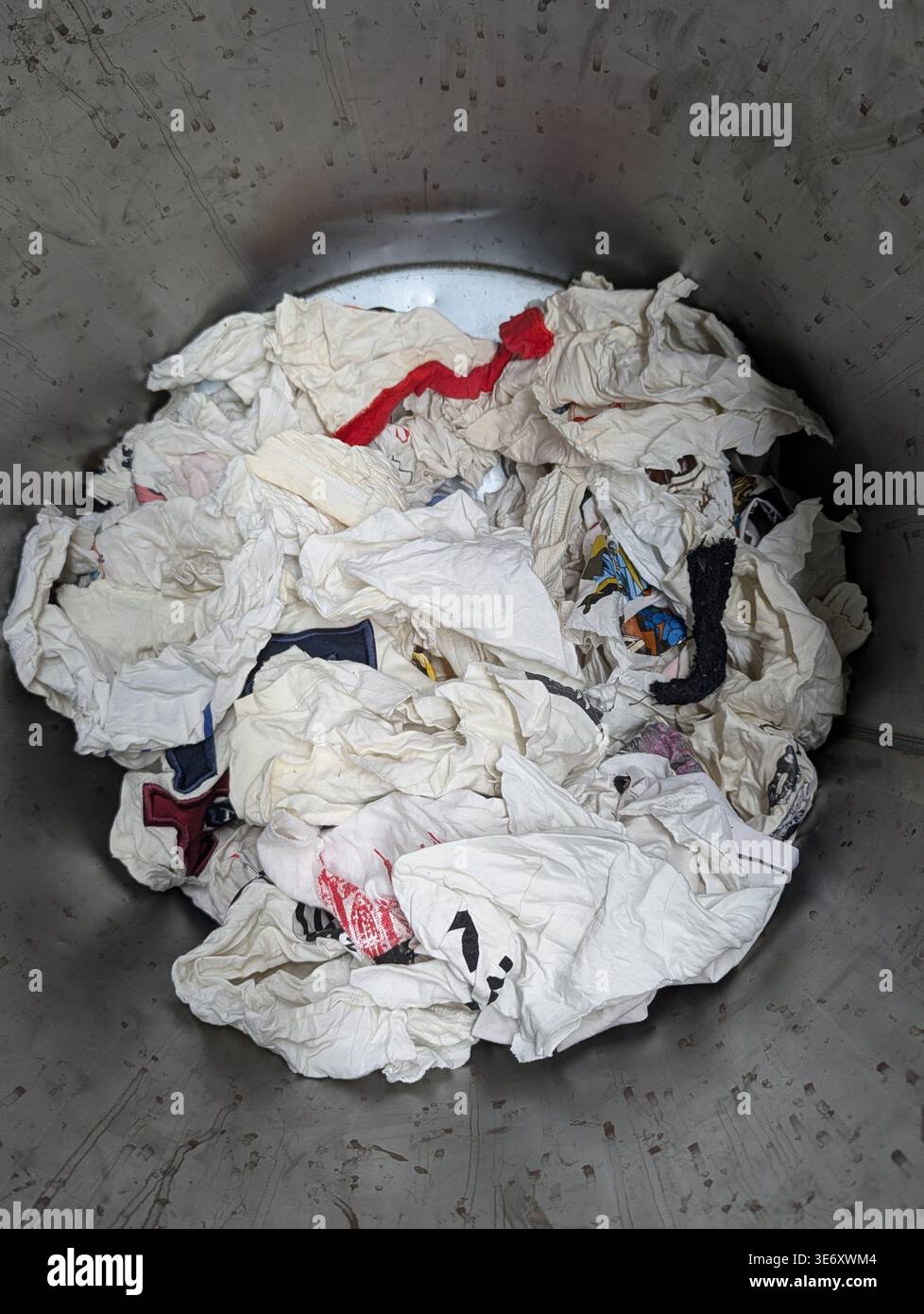 Zerknitterte Wäsche Im Metallbehälter, Gemischte Baumwollbekleidung Und -Socken, Gebeizte Handtuchreste, Industriebeton Hintergrund, Dimmen Beleuchtung, Offene Haushalts Cl Stockfoto