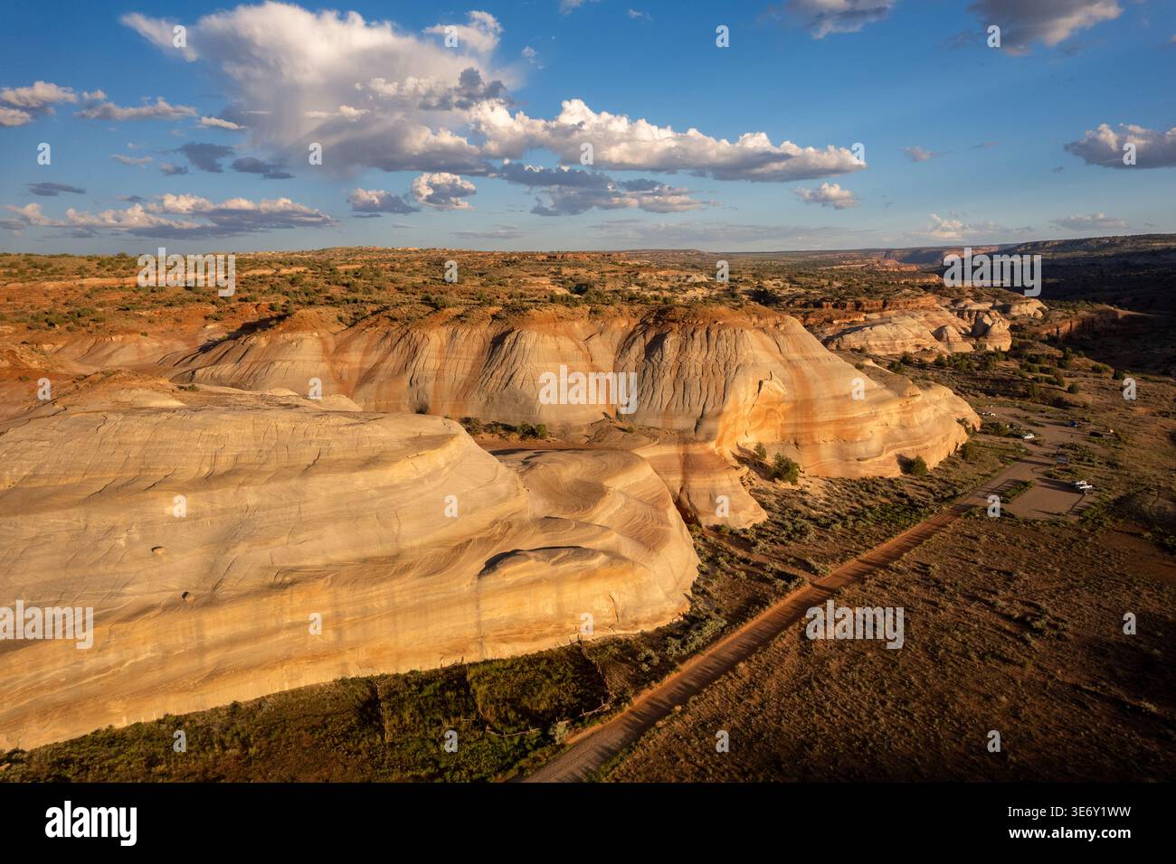 Aus der Vogelperspektive sehen Sie die bunt gestreiften Sandsteinhügel und die Wüstenlandschaft in Utah Badlands unter dramatischen Wolken, USA. Stockfoto