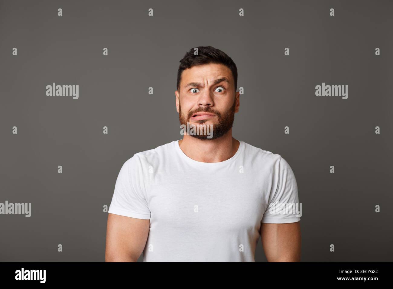 Muskulöse mann Grimassen schuldig Gesicht an Studio Stockfoto