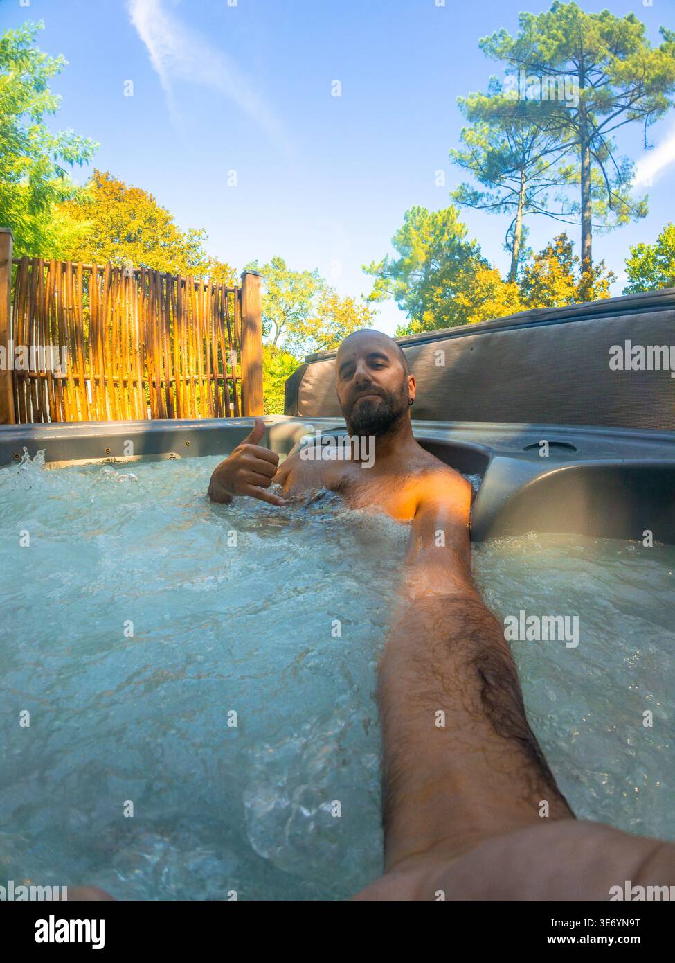 Mann genießt entspannende Momente im Wannen-Whirlpool im Freien Stockfoto
