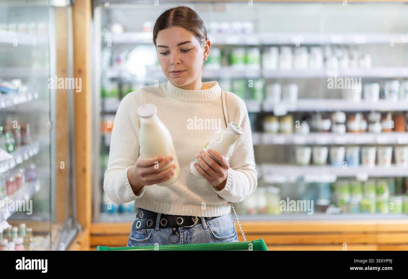 Frau wählt Milchprodukte Stockfoto