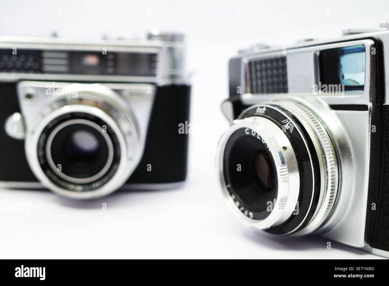 Nahaufnahme zweier analoger Vintage-Kameras. Beide haben silberne Gehäuse mit schwarzen Details. Die Objektive sind markant, mit Fokusringen und blendenmarkierung Stockfoto