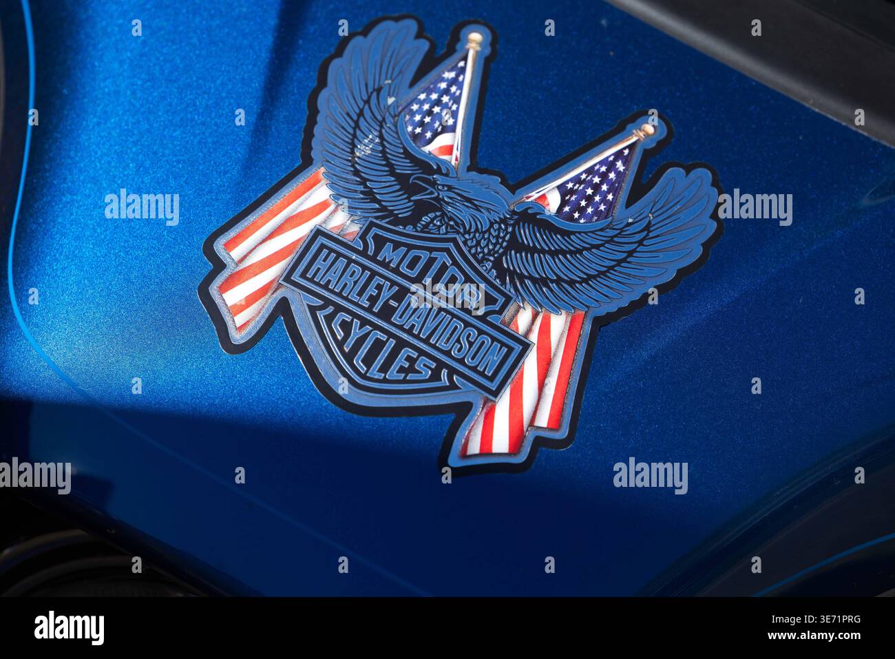 Villach, Österreich - 04. September 2025: Harley-Davidson-Logo mit Adler und Fahnen auf blauer Oberfläche, das Markenerbe und Motorradkultur unterstreicht Stockfoto