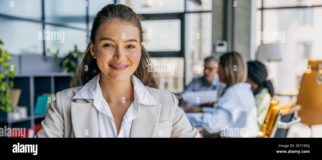 Unternehmerin verströmt Mut in festlicher Arbeitsumgebung Stockfoto