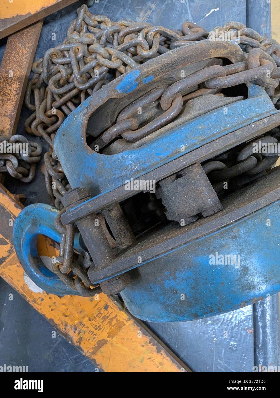 Blaue Hebezeuge Und Schwere Kettenabdeckungen, Die Haken, Glieder Und Riemenscheibenkomponenten Mit Lackverschleiß Und Oberflächenrost Zeigen, Deuten Auf Lagerrigging Hin. Stockfoto
