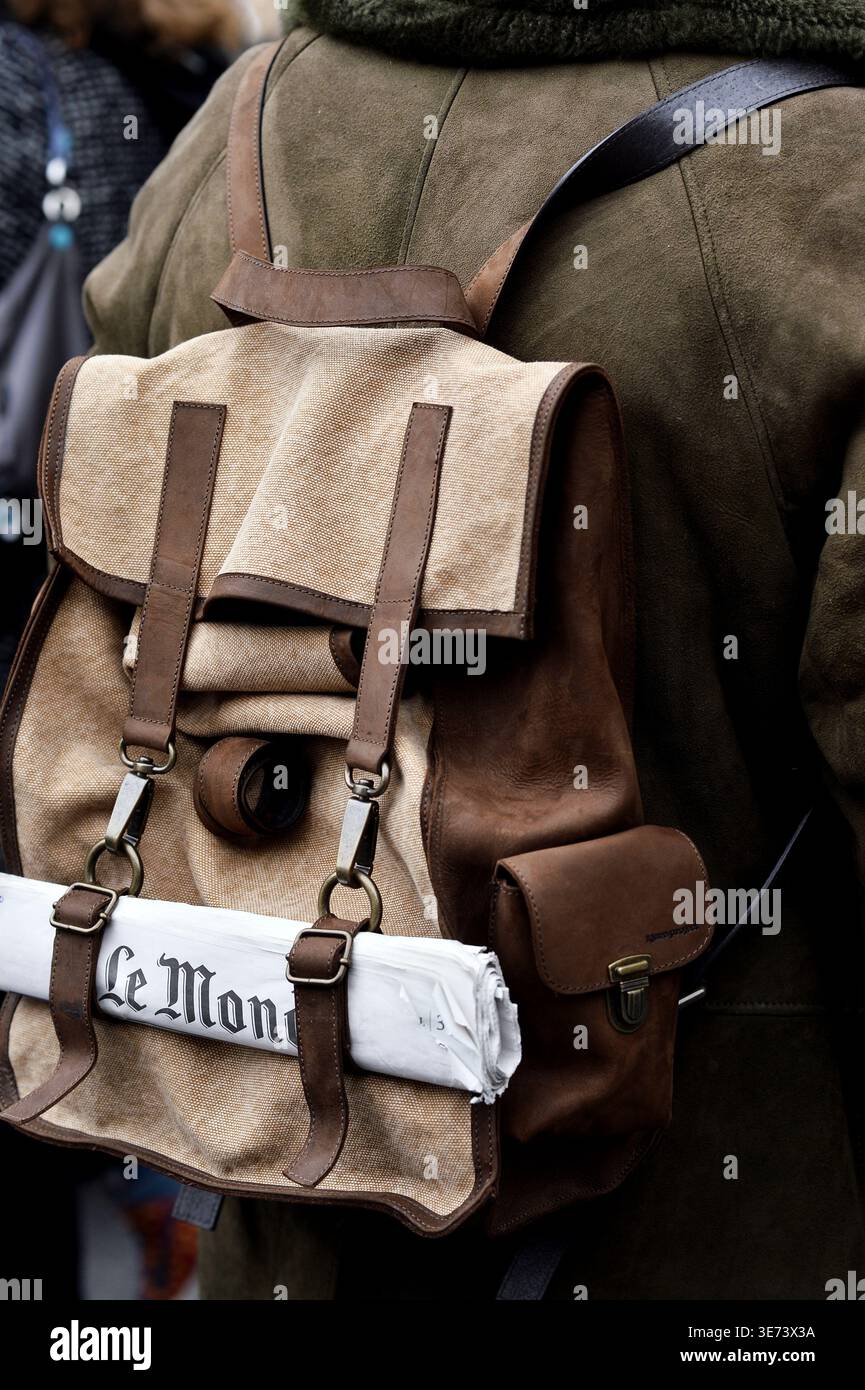 Ein Gast während der Pariser Fashion Week, der die französische Zeitung „Le Monde“ auf seinem Rucksack hält - Frankreich Stockfoto