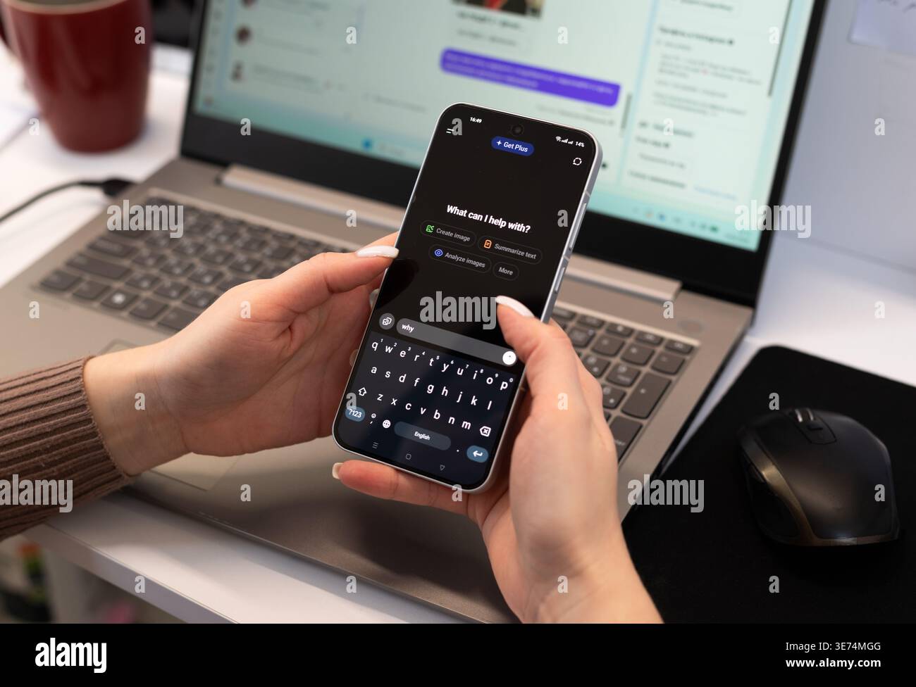 Kiew, Ukraine. Februar 2026. Frau, die die mobile ChatGPT-App auf einem Smartphone an einem Schreibtisch mit Laptop nutzt. Künstliche Intelligenz und Fernarbeit. Stockfoto