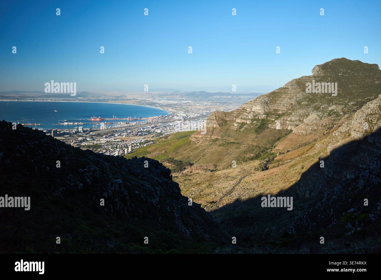 Mountain Pass Vista. Malerischer Blick Auf Die Stadt Und Das Meer. Sonnendurchflutete Bergschlucht Mit Stadt In Der Ferne Stockfoto