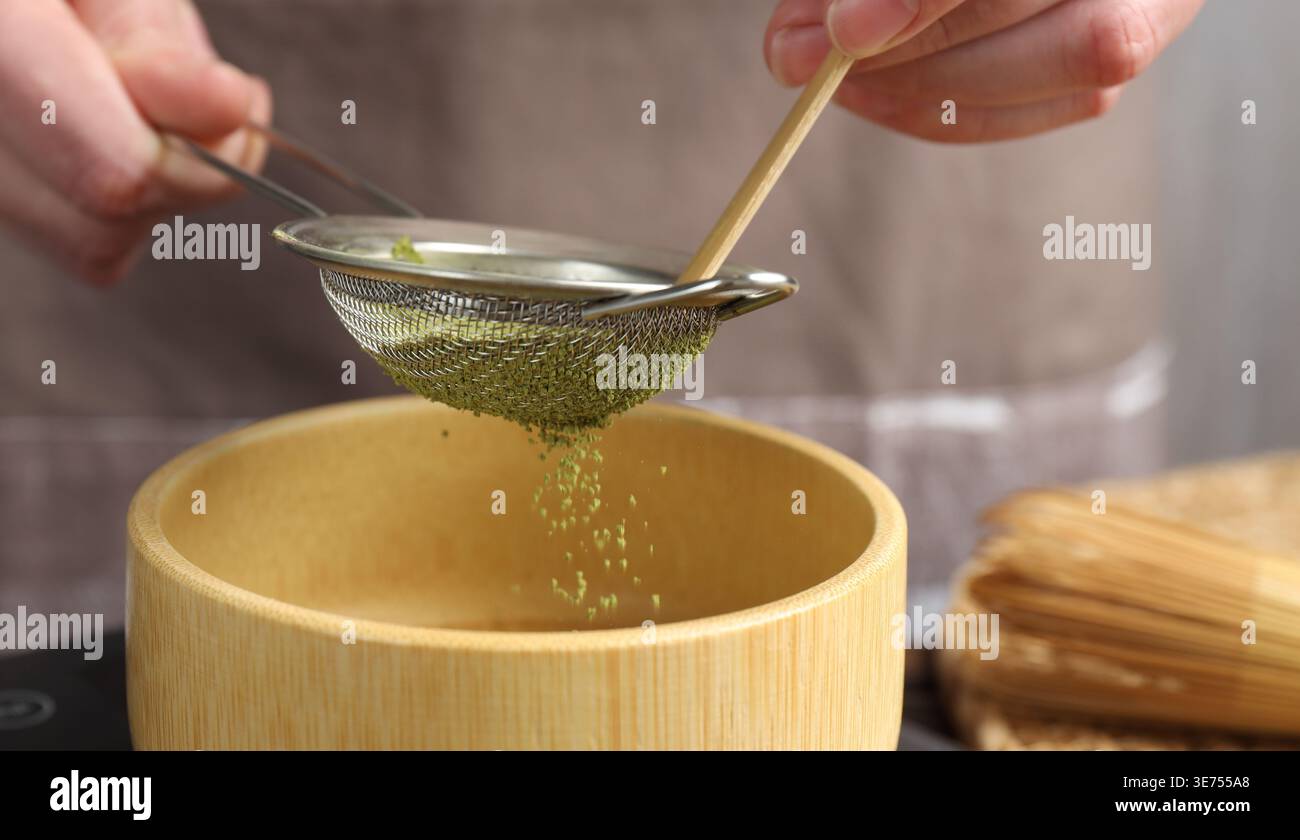 Frau, die Matcha-Pulver in eine Schüssel siebt, Nahaufnahme Stockfoto
