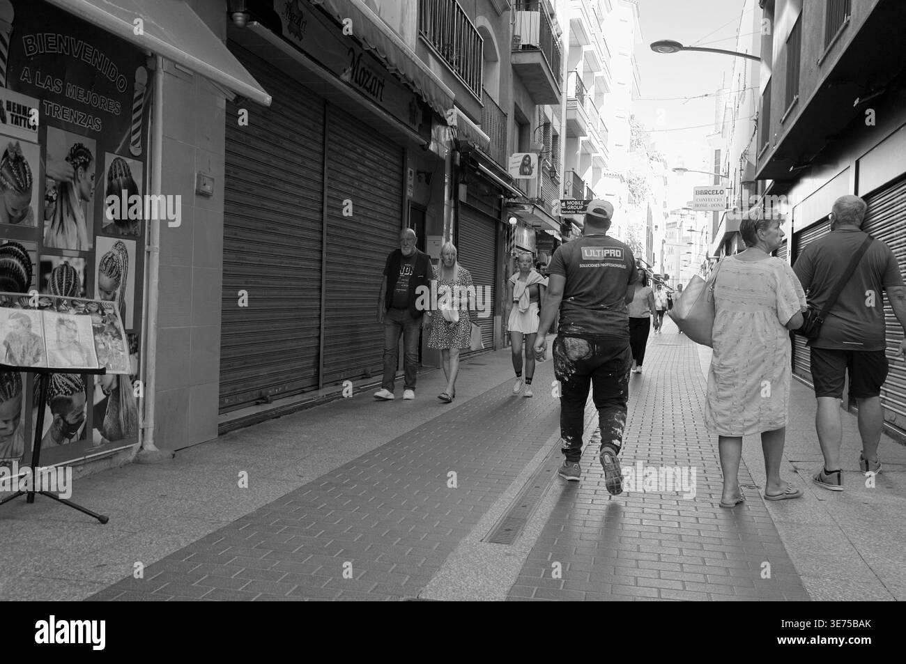 Lloret de Mar, Spanien - 7. September 2024 Ein schwarz-weißer Blick auf die Straße, wo Menschen durch eine enge Fußgängerzone mit Geschäften und Spaziergängen gehen Stockfoto