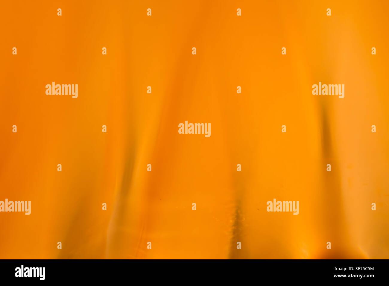 Kräftige, abstrakte Seidenstruktur in Orange mit sanften Wellen und eleganter Beleuchtung Stockfoto
