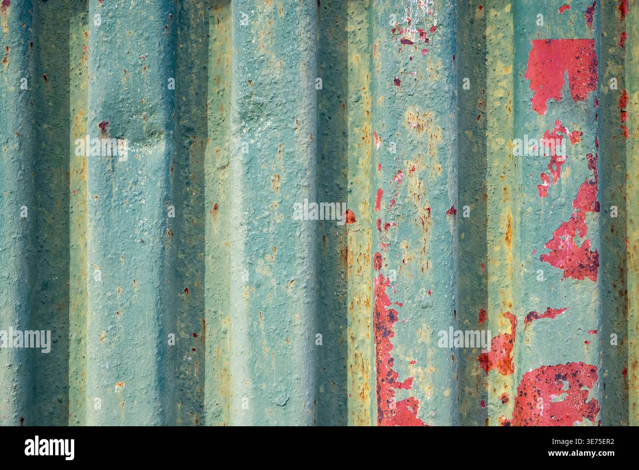 Vertikales Metallprofil mit grüner Farbe und roten Rostflecken. Stockfoto