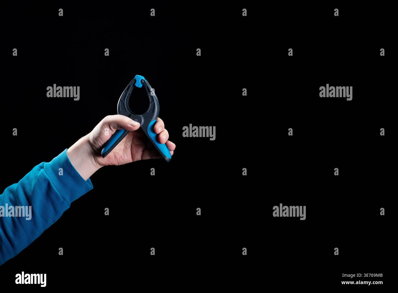 Hand hält das blaue Klemmwerkzeug nahe oben Stockfoto