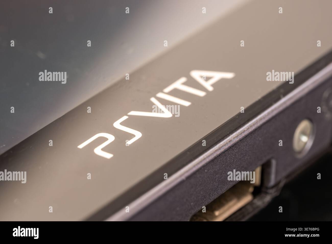 Sony PS Vita Handheld-Spielkonsole Nahaufnahme mit PSVita-Logo und Ladeanschluss, dunklem Hintergrund und geringer Schärfentiefe Stockfoto