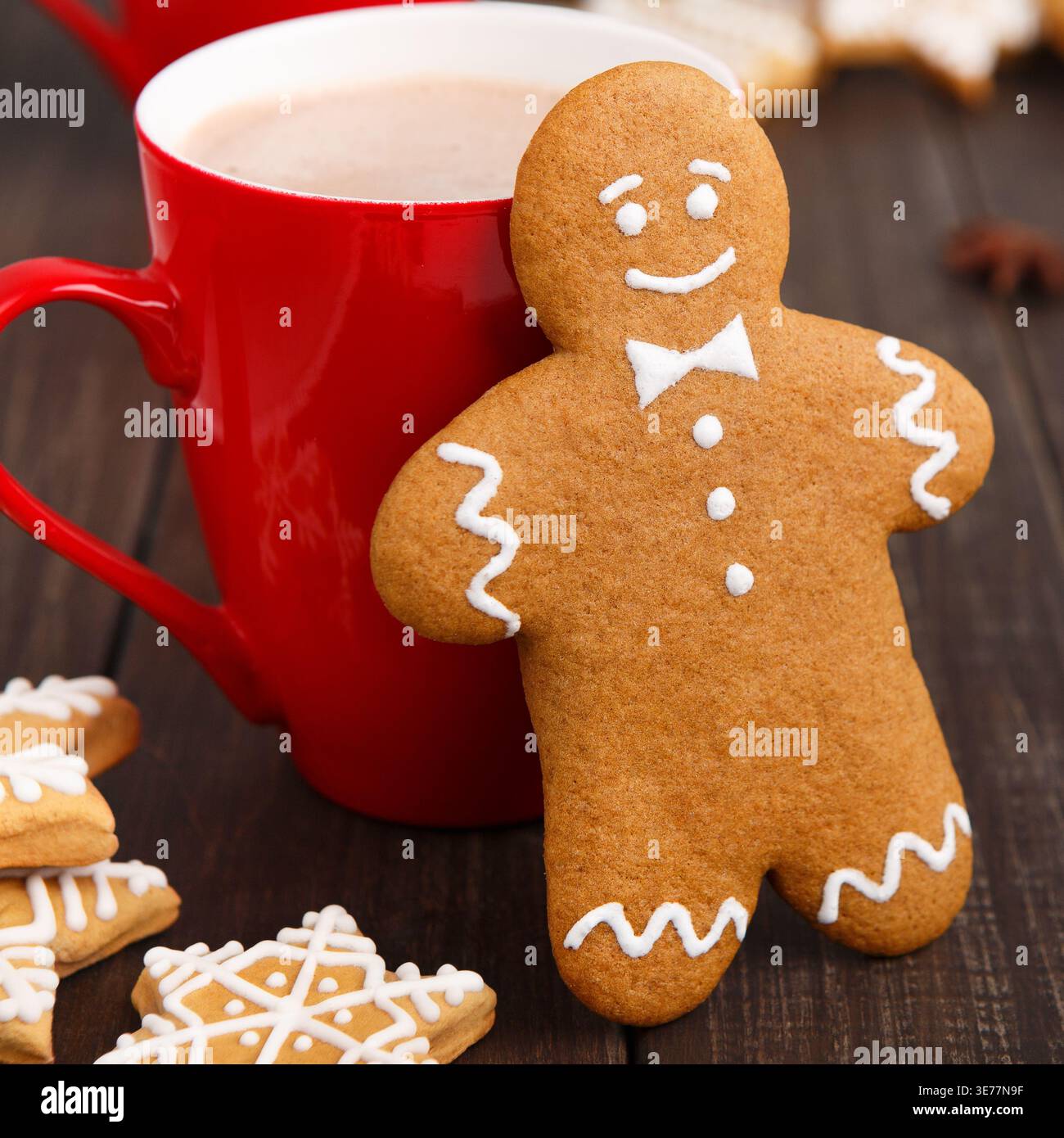 Erstellen Sie eine Weihnachtscollage mit Lebkuchenkeksen und heißer Schokolade auf einem Holztisch Stockfoto
