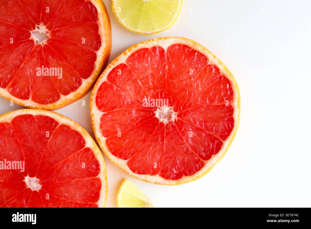 Frisch geschnittene Grapefruitscheiben isoliert auf weißem Hintergrund, knallige rosa oder rote Zitrusfruchtstücke mit saftiger Textur, gesundes natürliches Lebensmittelkonzept. Stockfoto