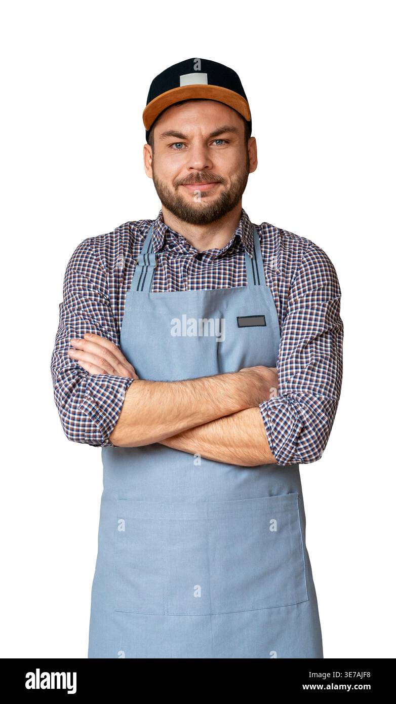 Porträt eines erwachsenen männlichen Unternehmers in Schürze und Kappe stehend mit gekreuzten Armen und Blick und Kamera, isoliert auf weißem Hintergrund. Stockfoto