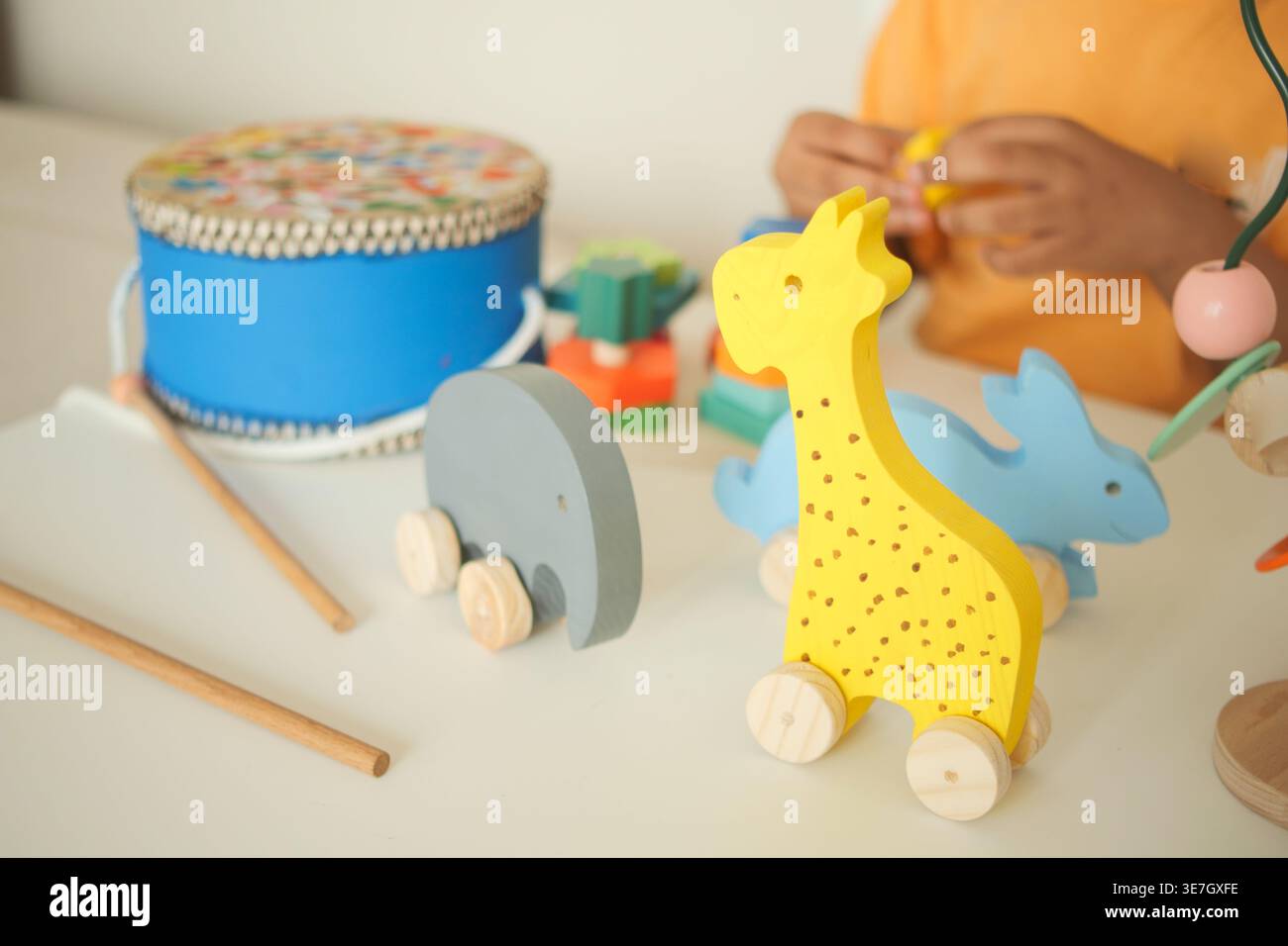 Das Kind spielt mit Holzspielzeug und Musikinstrumenten Stockfoto