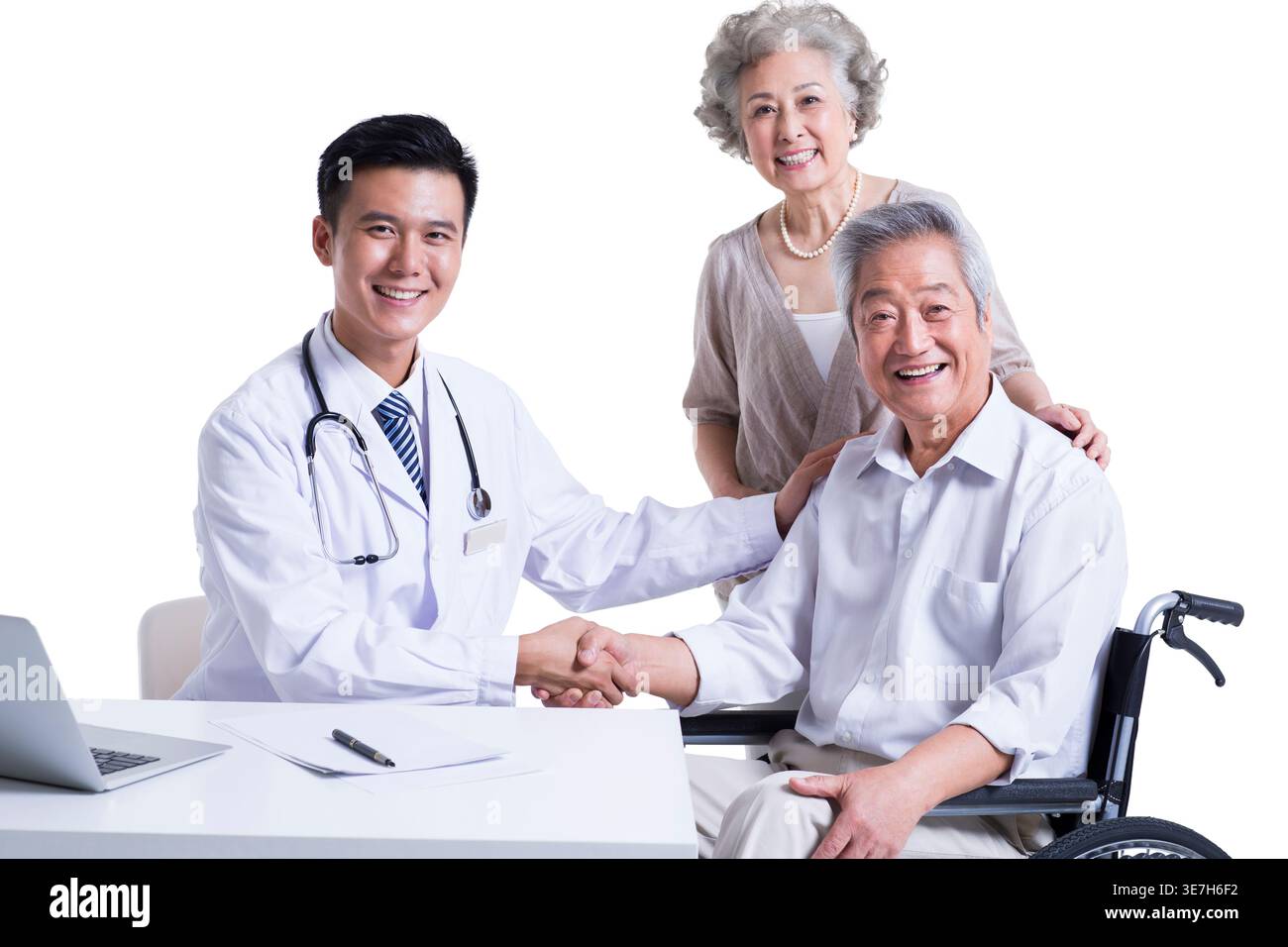 Ein lächelnder chinesischer Arzt schüttelt einem älteren chinesischen Mann die Hand, während er in der Nähe einer älteren chinesischen Frau vor weißem Hintergrund im Studio sitzt Stockfoto