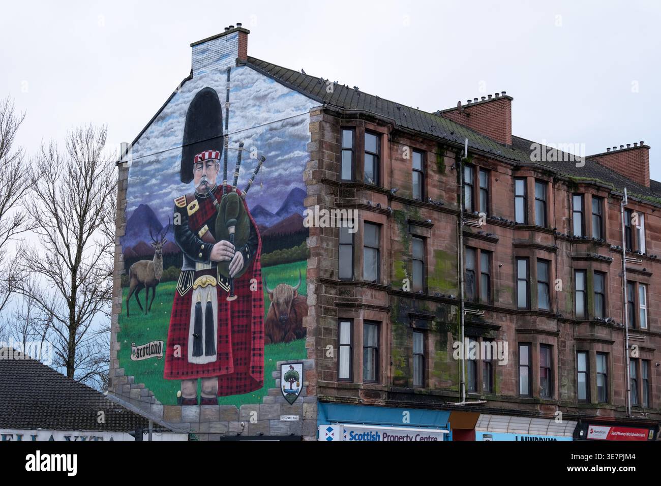 Bagpiper Wandgemälde von Dan McDermott auf dem Mietshaus, schottischer Bagpiper in Kilt Street Art, Cardonald, Glasgow, Schottland. Stockfoto