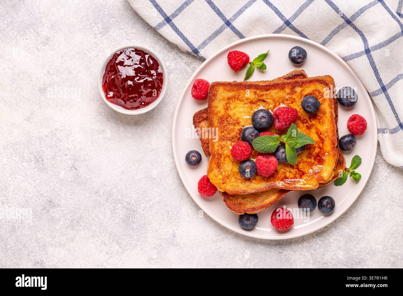 Französischer Toast mit Heidelbeeren, Himbeeren, Ahornsirup, Blick von oben. Stockfoto
