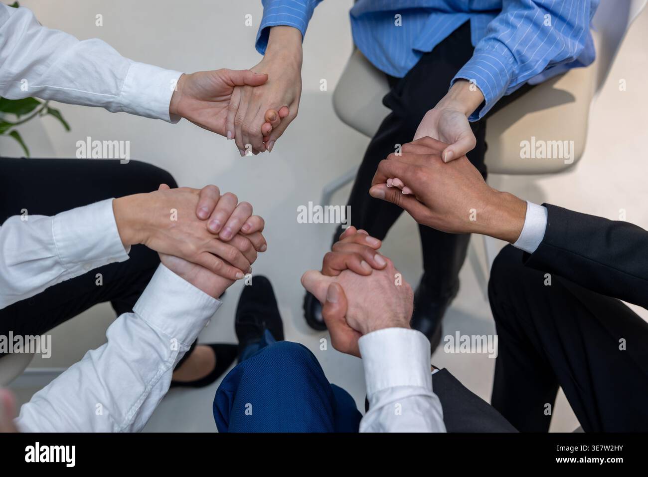 Schwarzer Mann mit kaukasischen Kollegen, die während der Psychotherapiesitzung im Kreis auf Stühlen sitzen Stockfoto