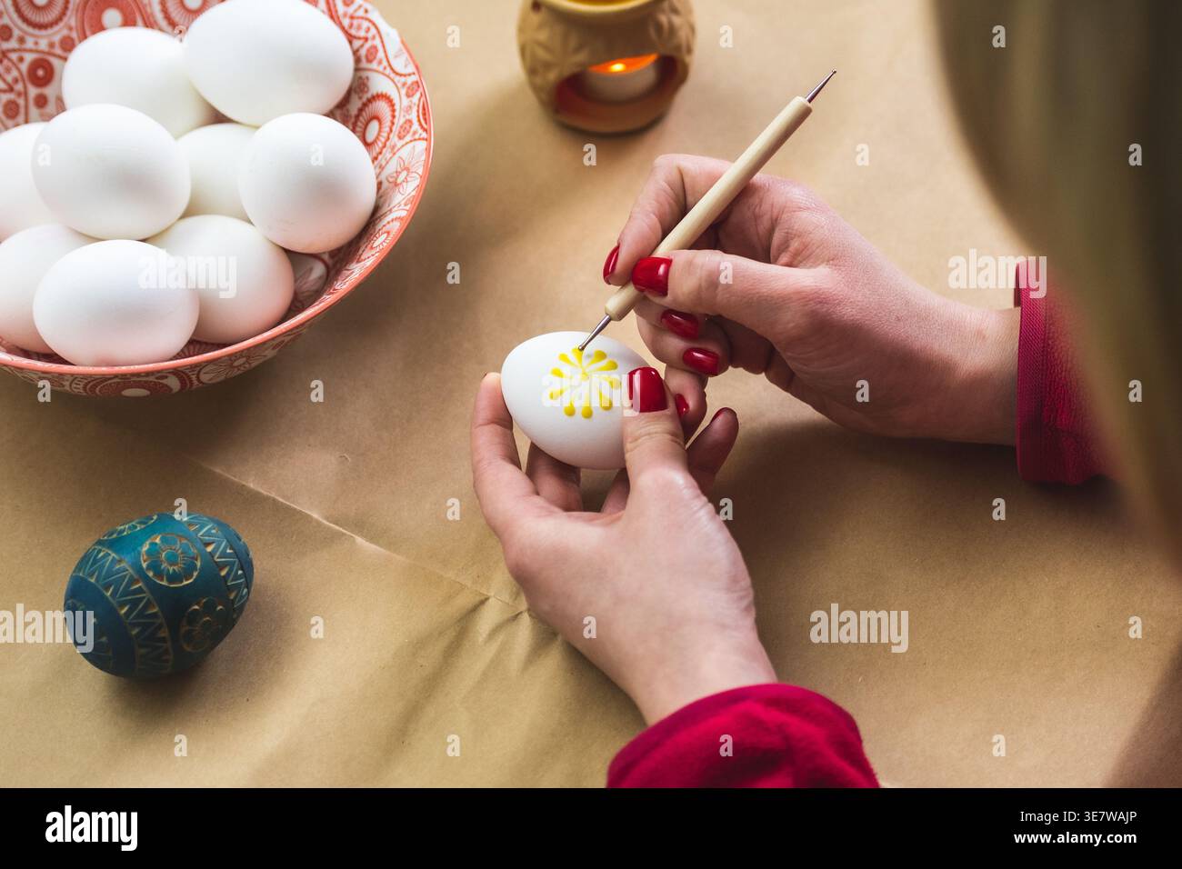 Litauisches Mädchen malt traditionelle Ostereier mit heißem Bienenwachs mit einer Nadel Stockfoto