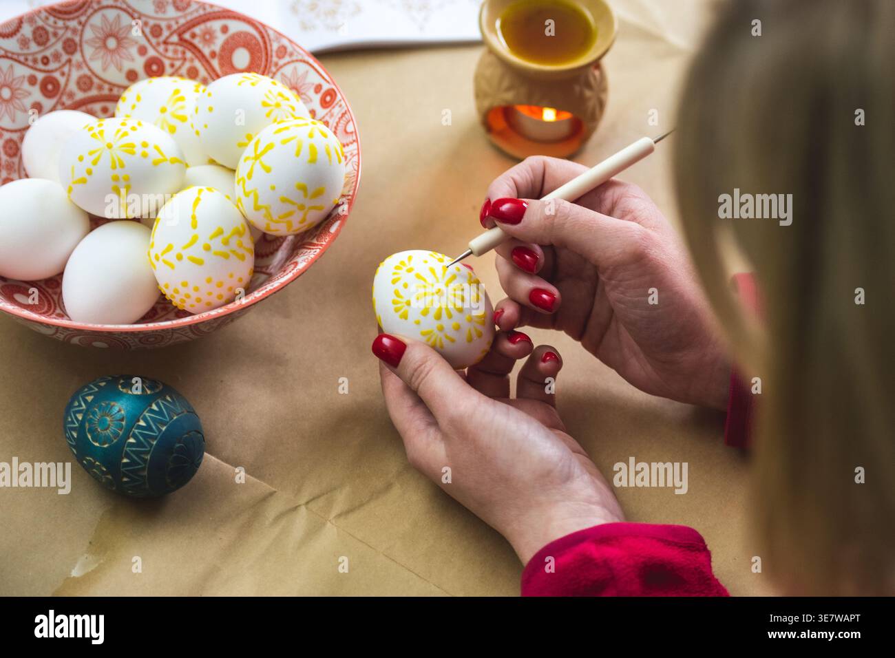 Litauisches Mädchen malt traditionelle Ostereier mit heißem Bienenwachs mit einer Nadel Stockfoto