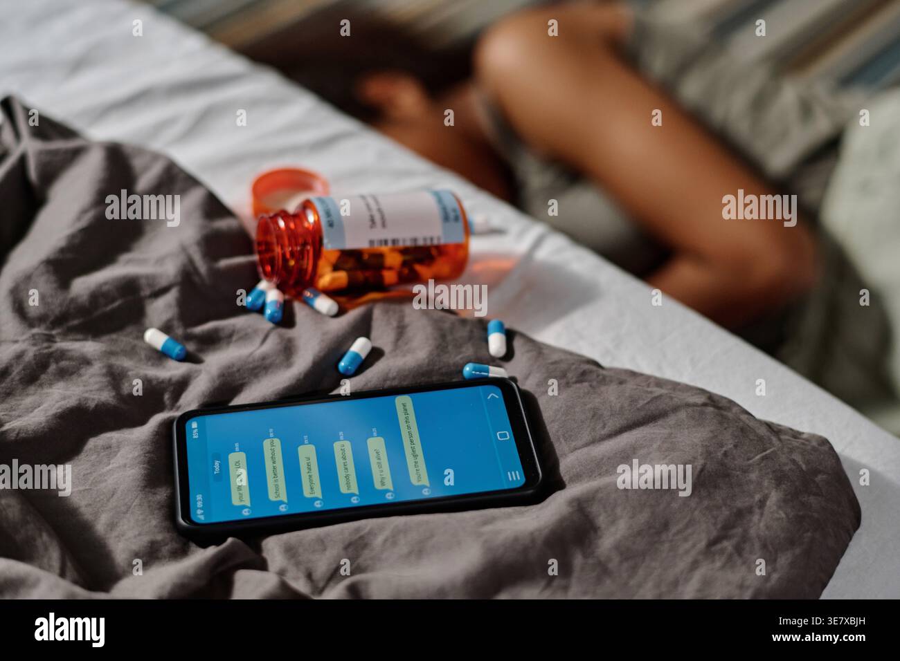 Schwarze Teenagerin beging Selbstmord nach Cybermobbing, die auf dem Boden lag, verstreute Pillen auf dem Bett mit Smartphone in ihrem Schlafzimmer Stockfoto