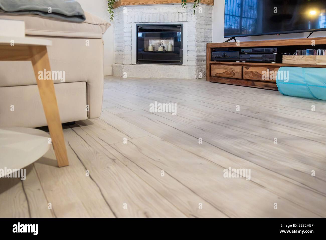Wohnzimmer mit Laminatfußboden und modernem Kamin Stockfoto