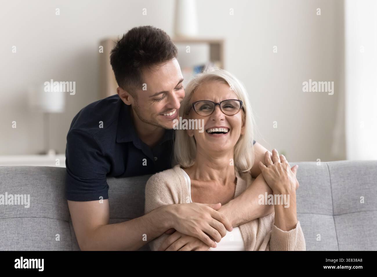 Schöne reife Frau genießt Kuscheln von liebevollem erwachsenem Sohn Stockfoto