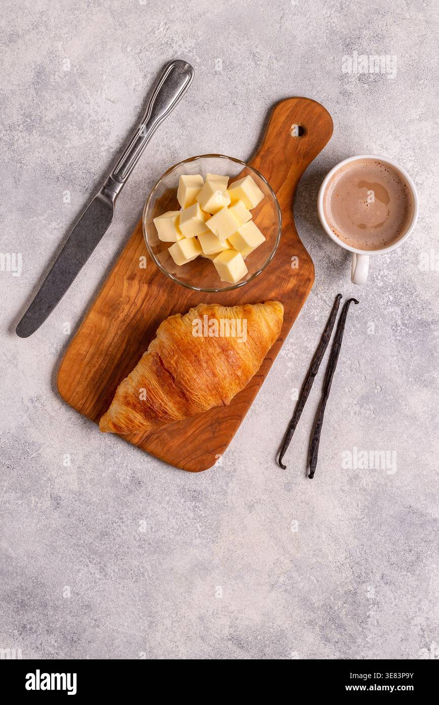 Französisches Croissant. Frisch gebackene Croissants mit Butterkaffee auf dunklem Steinhintergrund. Stockfoto