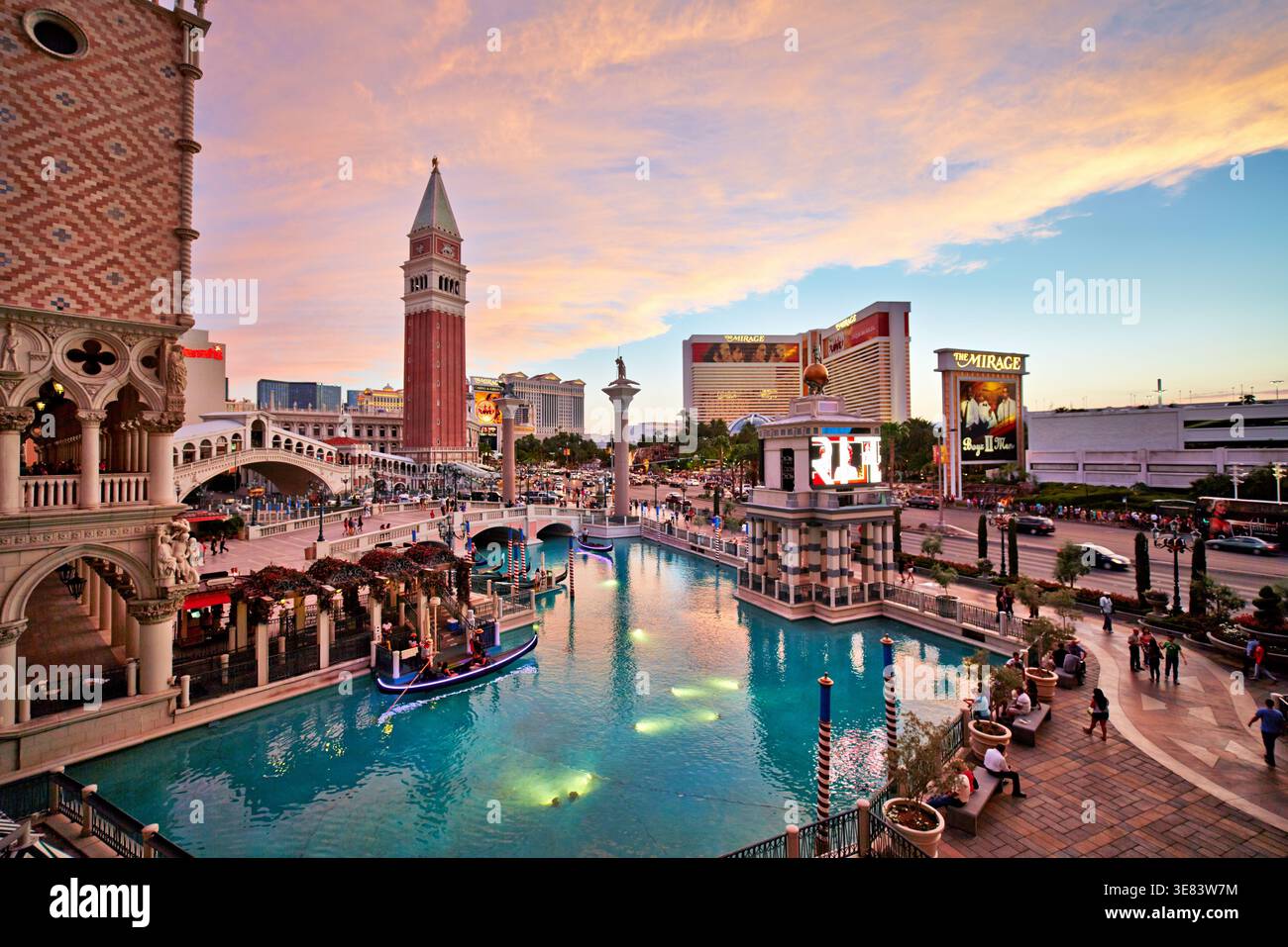 Während des Sonnenuntergangs spazieren die Menschen am Wasserweg des Venetian Hotels entlang. Die Skyline von Las Vegas ist im Hintergrund zu sehen. Stockfoto