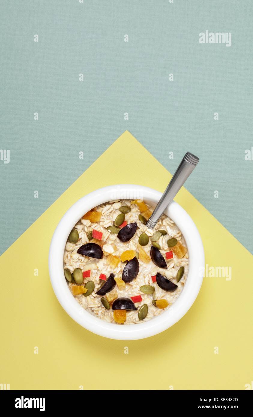 Weiße Schüssel mit Hafer und Früchten Stockfoto