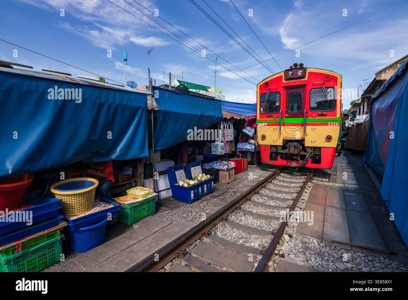 Der Zug fährt durch den Maeklong Railway Market mit Ständen und Regenschirmen, Samut Songkhram, Thailand Stockfoto
