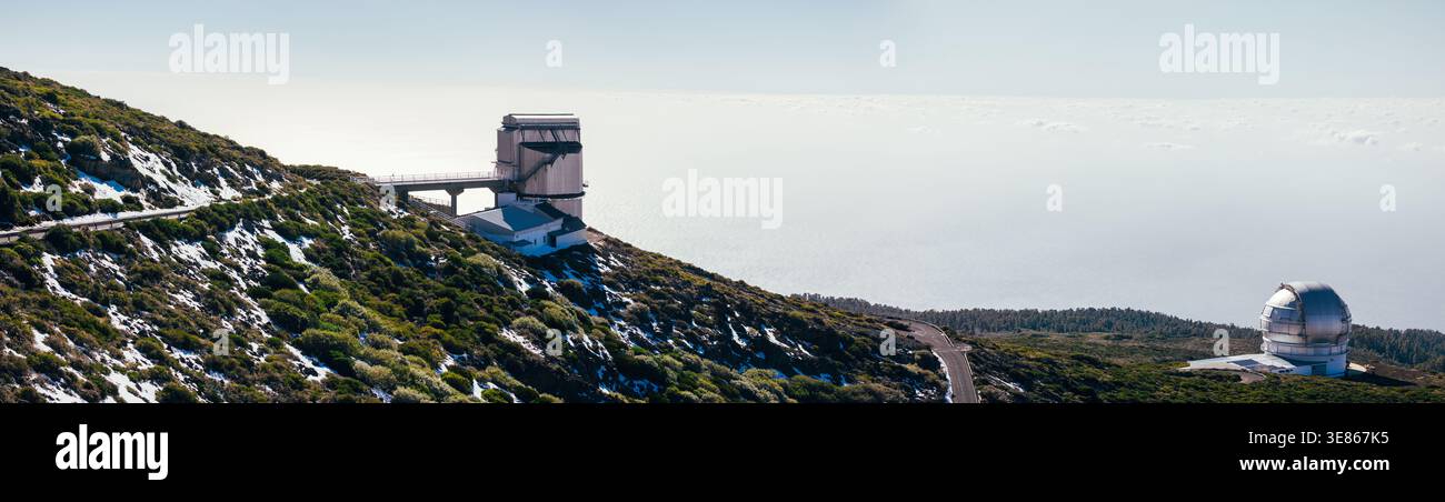 Panoramablick auf das Observatorium Roque de los Muchachos auf der Insel La Palma, Spanien, mit modernen Teleskopkuppeln, gewundenen Straßen und zerklüftetem vulkanischem Hang u Stockfoto