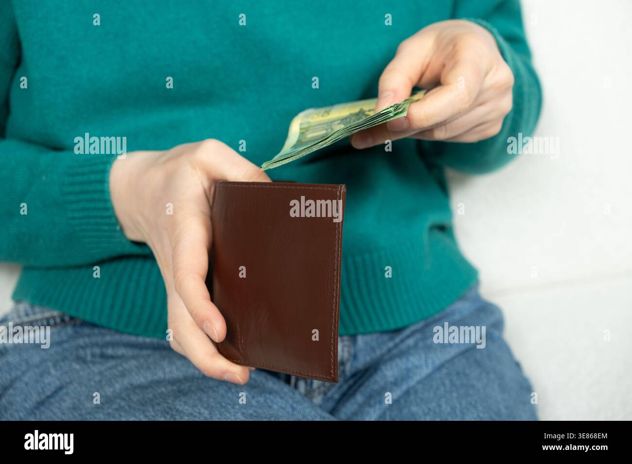 Hände haben die Papierscheine in Nahaufnahme in die Brieftasche gelegt Stockfoto