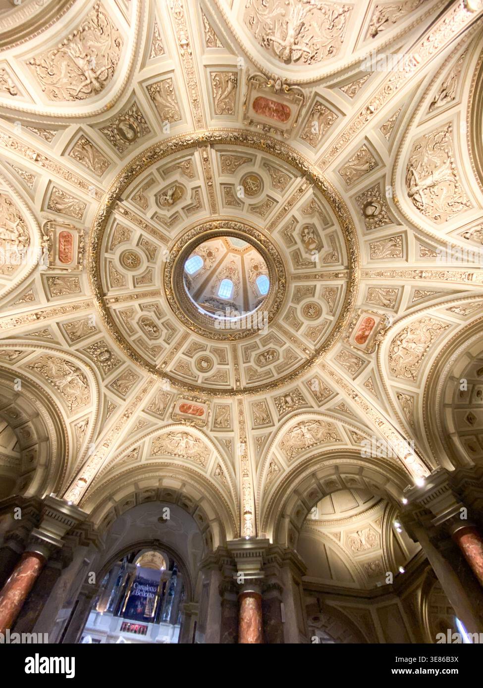 Flacher Blick auf eine reich verzierte Kuppel mit symmetrischen Ornamenten, Basreliefs und Goldakzenten. Wien, Österreich, 21. März 2026. Stockfoto