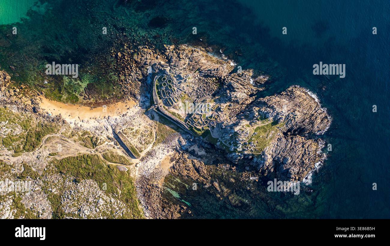 Atemberaubende Luftaufnahme von Castro de Baroña, einer keltischen Siedlung aus der Eisenzeit in Galicien. Das Bild zeigt kreisförmige Steinhäuser, die sich auf einer r Stockfoto