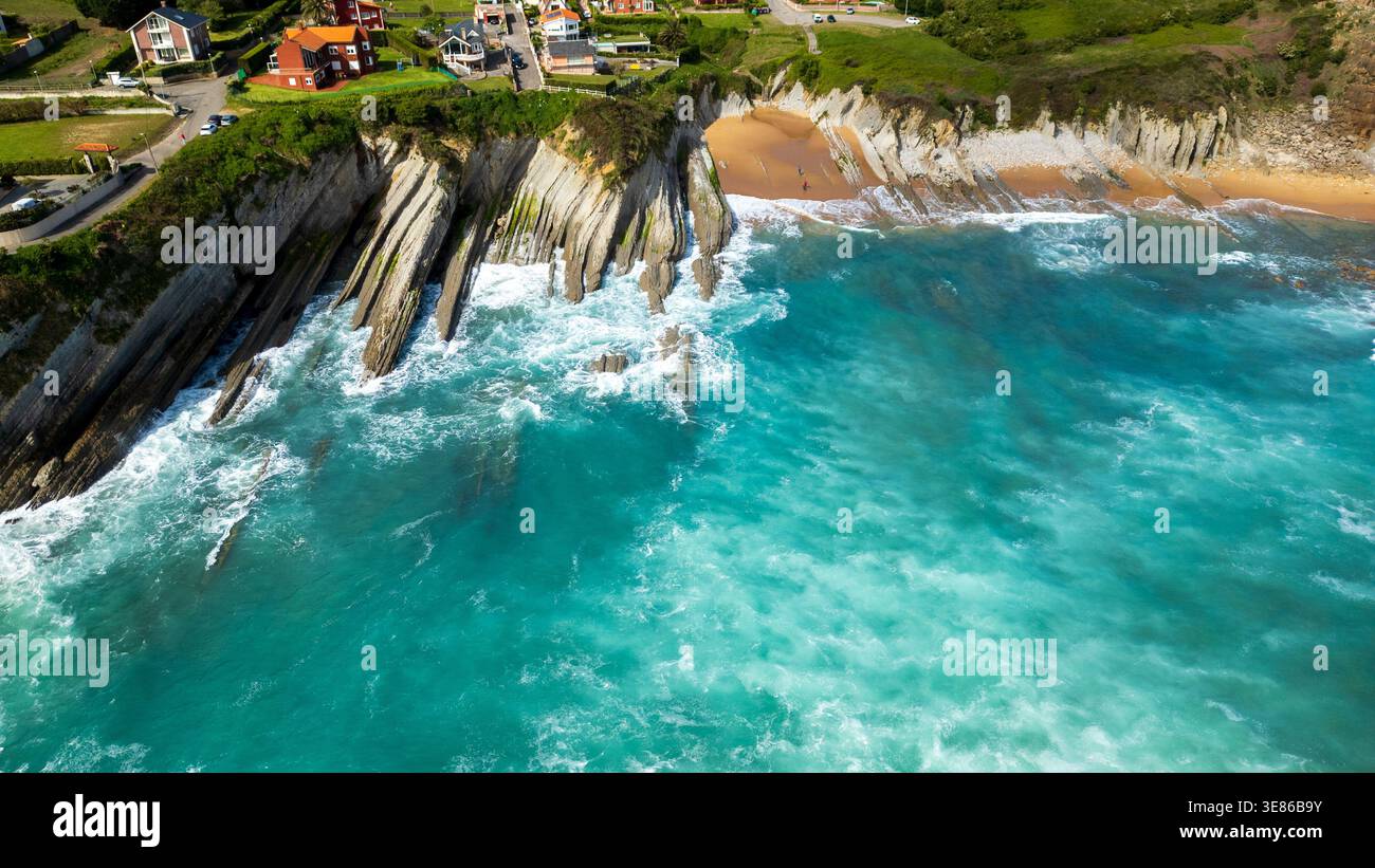 Atemberaubender Blick aus der Luft auf den Strand von Arnia in Kantabrien, Spanien. Das Bild zeigt einzigartige geologische Flysch-Formationen, türkisfarbenes Wasser und eine Küstenville Stockfoto
