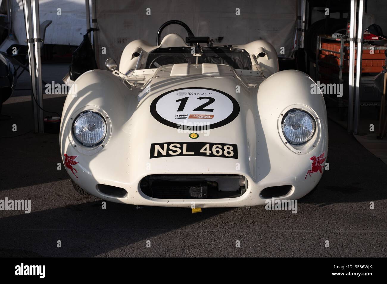 Vorderansicht eines weißen Lister Knobble Chevrolet klassischen Sportrennwagens mit Rennnummer 12 und Nummernschild NSL 468, geparkt unter einem Vordach in A p Stockfoto