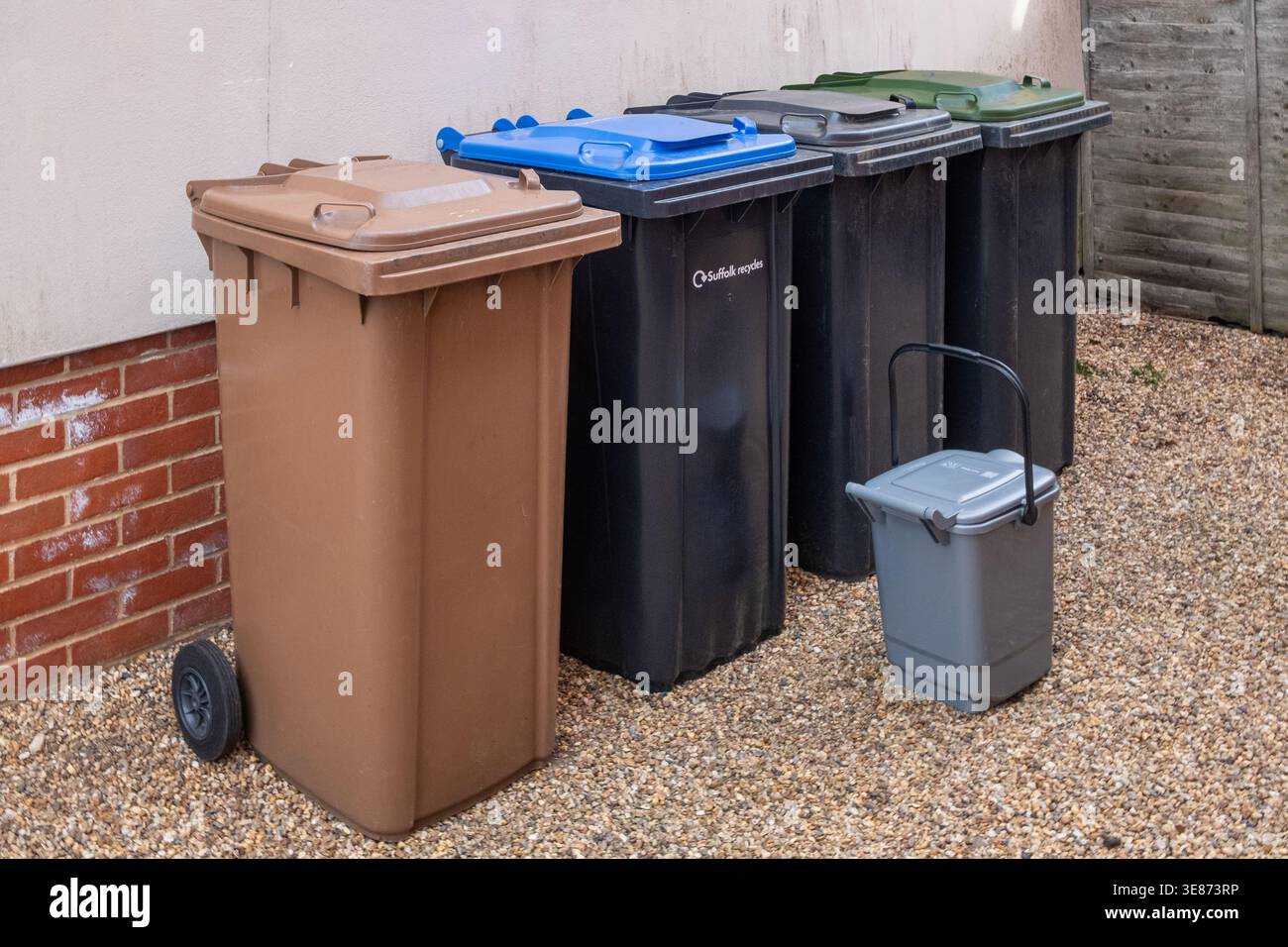 Recycling und Abfallbehälter. Suffolk, Großbritannien. Braun - Gartenabfälle, blau - Behälter, schwarz - allgemeiner Müll, grün - Papier und Karton, grauer Caddy - Lebensmittelabfälle. Stockfoto