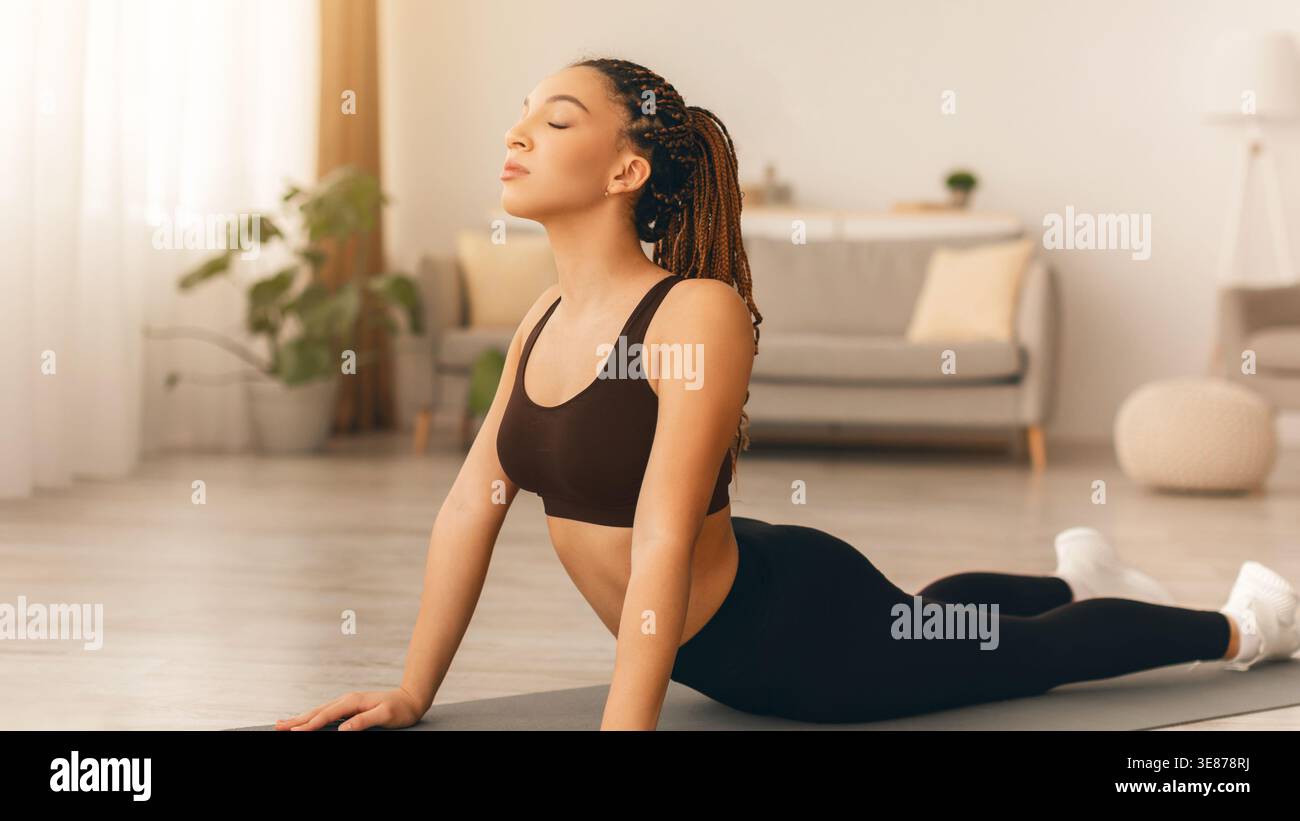 Yoga-Praxis in einem modernen Wohnzimmer mit natürlichem Licht und Pflanzendekor Stockfoto