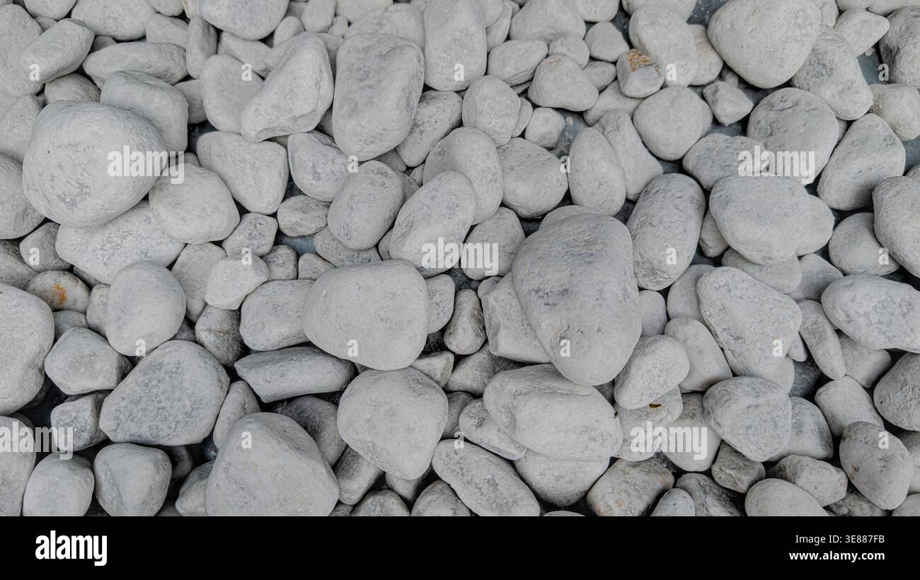 Glatter weißer und grauer Hintergrund mit Meeressteinen Stockfoto