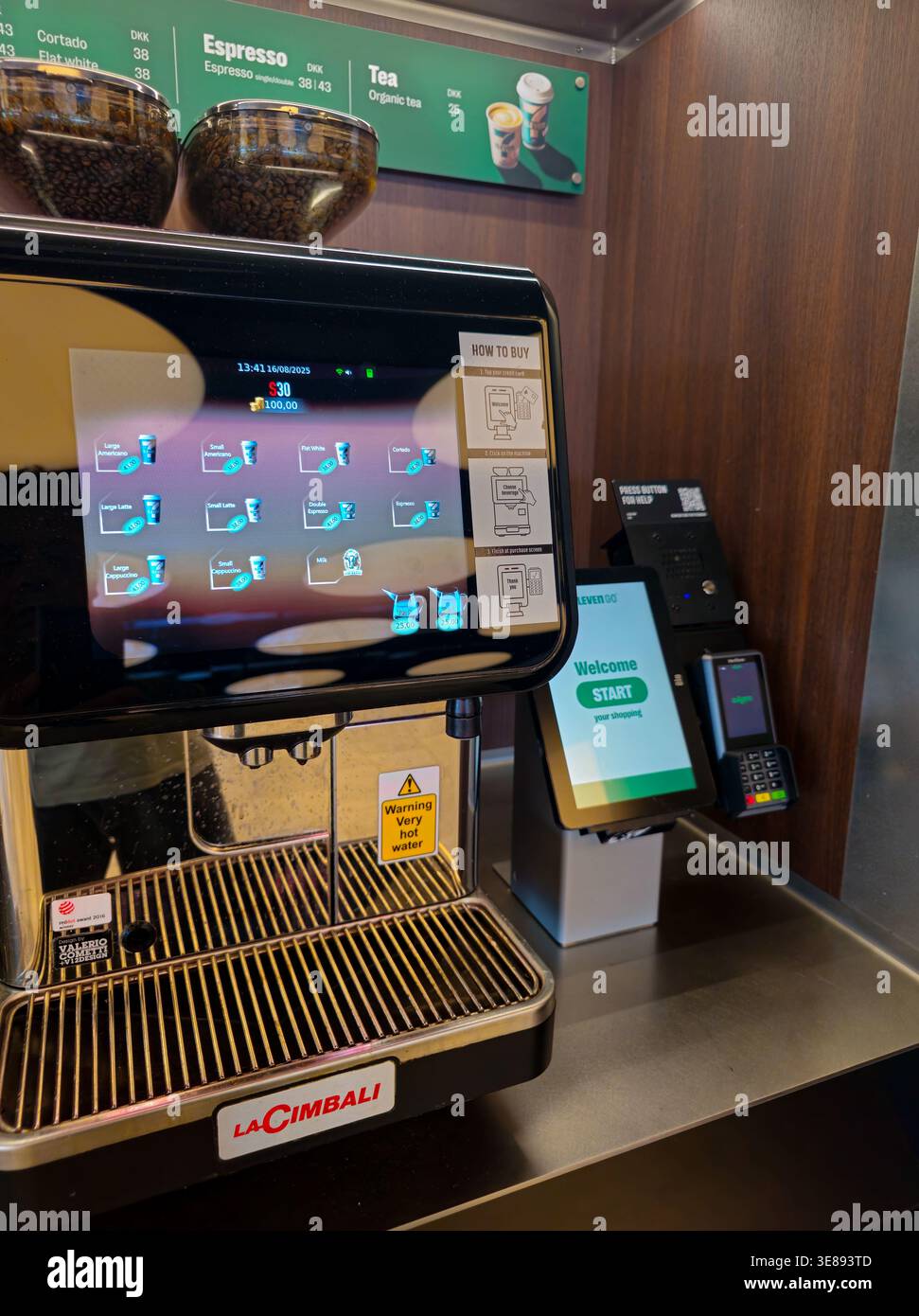 Kopenhagen, Dänemark, 16. August 2025: Selbstbedienungs-Kaffeemaschine mit verschiedenen heißen Getränken, Touchscreen-Menü und Zahlungsterminal Stockfoto