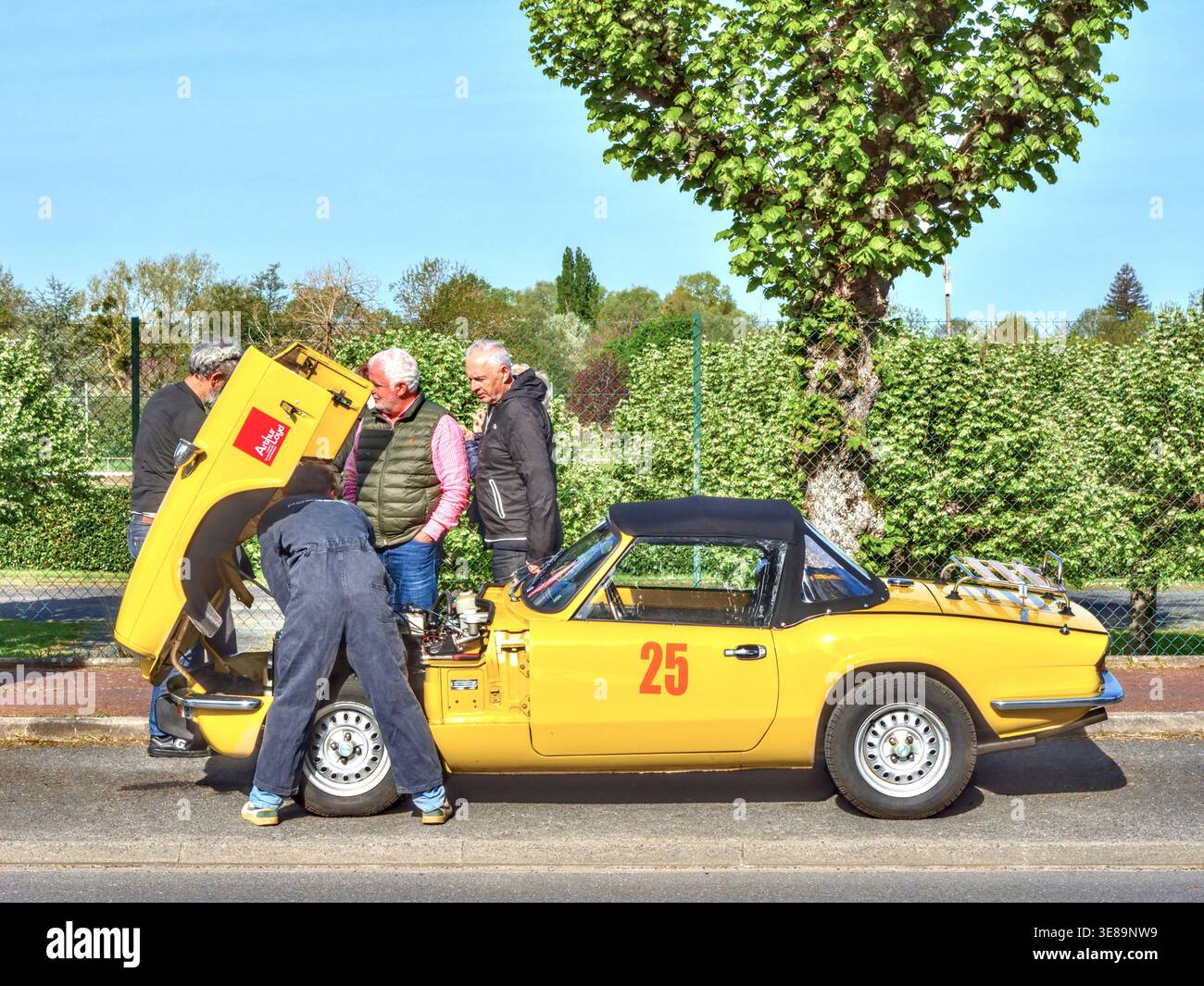 Mechaniker arbeitet an einem Triumph Spitfire während einer Oldtimer-Rallye in Zentralfrankreich. Stockfoto
